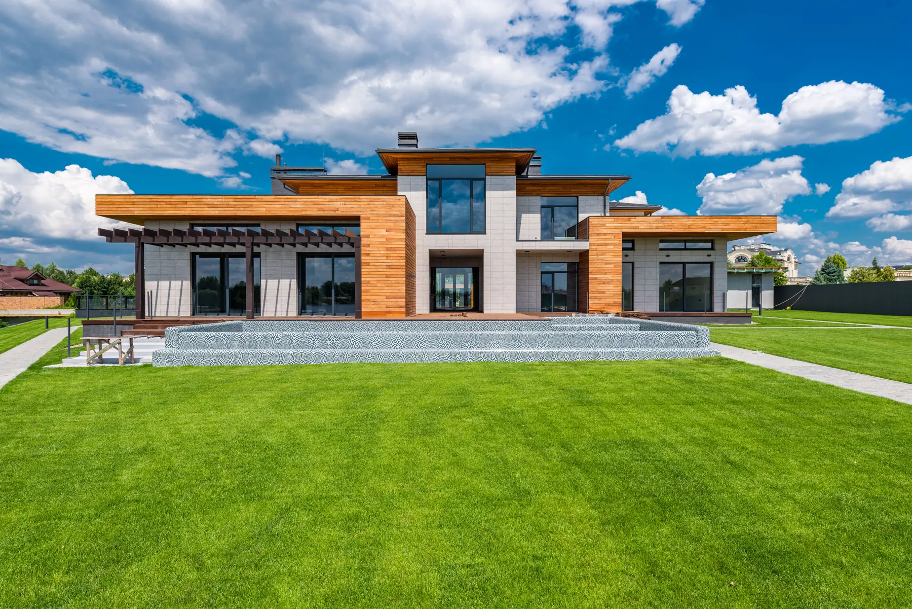 Villa Horizon à Bridel, façade contemporaine en pierre et bois devant une large pelouse